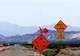 Highway in desert with traffic cones and signs saying ‘Be prepared to stop’ and ‘Subject to Flooding’