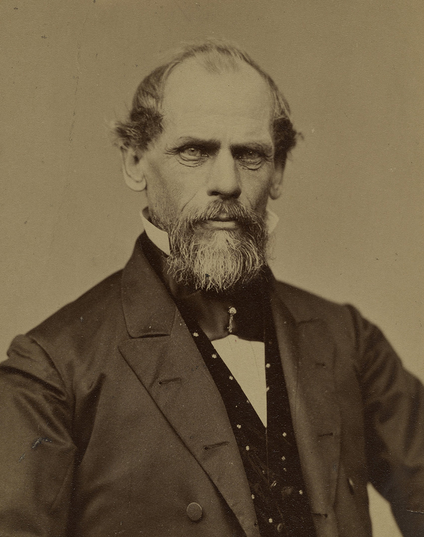 Black and white photograph of a man with a beard in a suit