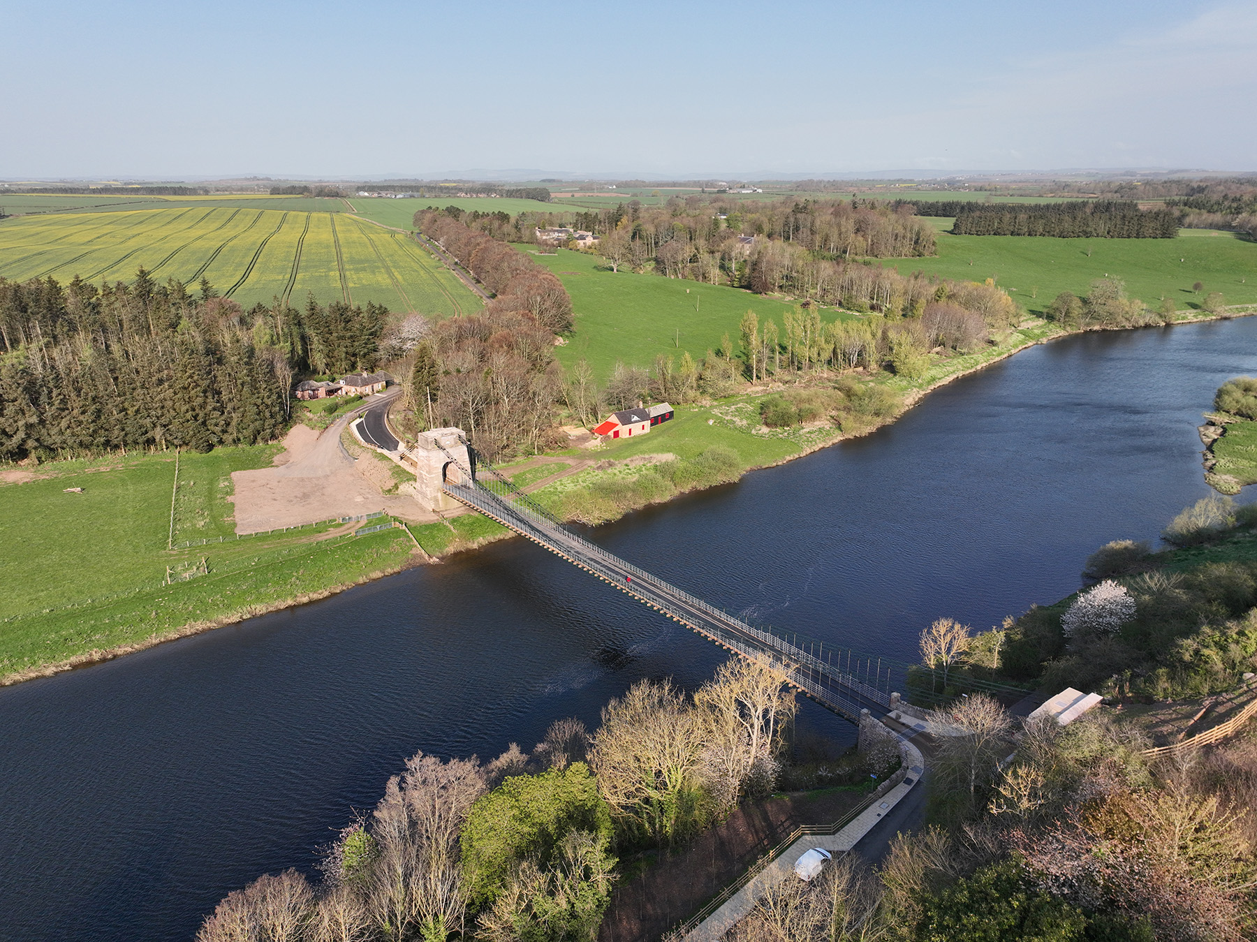 A bridge with a long deck spans a body of water. 