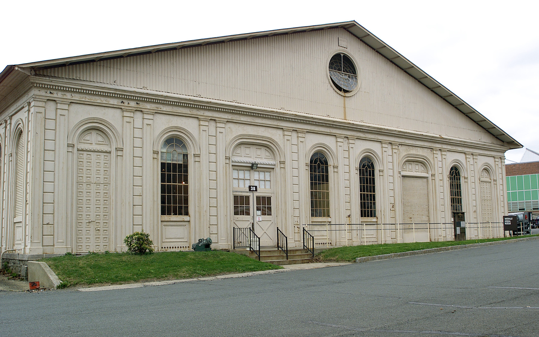 building facade showing four windows and one door. the building has a triangular roof