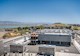 A multibuilding campus sits next to a filled landfill and large body of water. 