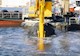 Sediment is being dredged from a body of water by large equipment. 